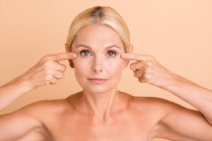 A woman pointing to her eyelids